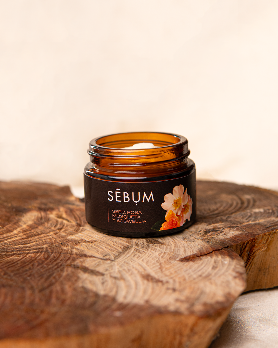 REAL-PHOTO | source: Drive Sebum/Fotografias/8.png | purpose: PDP gallery lifestyle (frasco abierto sobre madera) | product: Bálsamo Ritual | variant: Sebo Rosa Mosqueta y Boswellia | packaging: frasco ambar | date: 2026-07-08